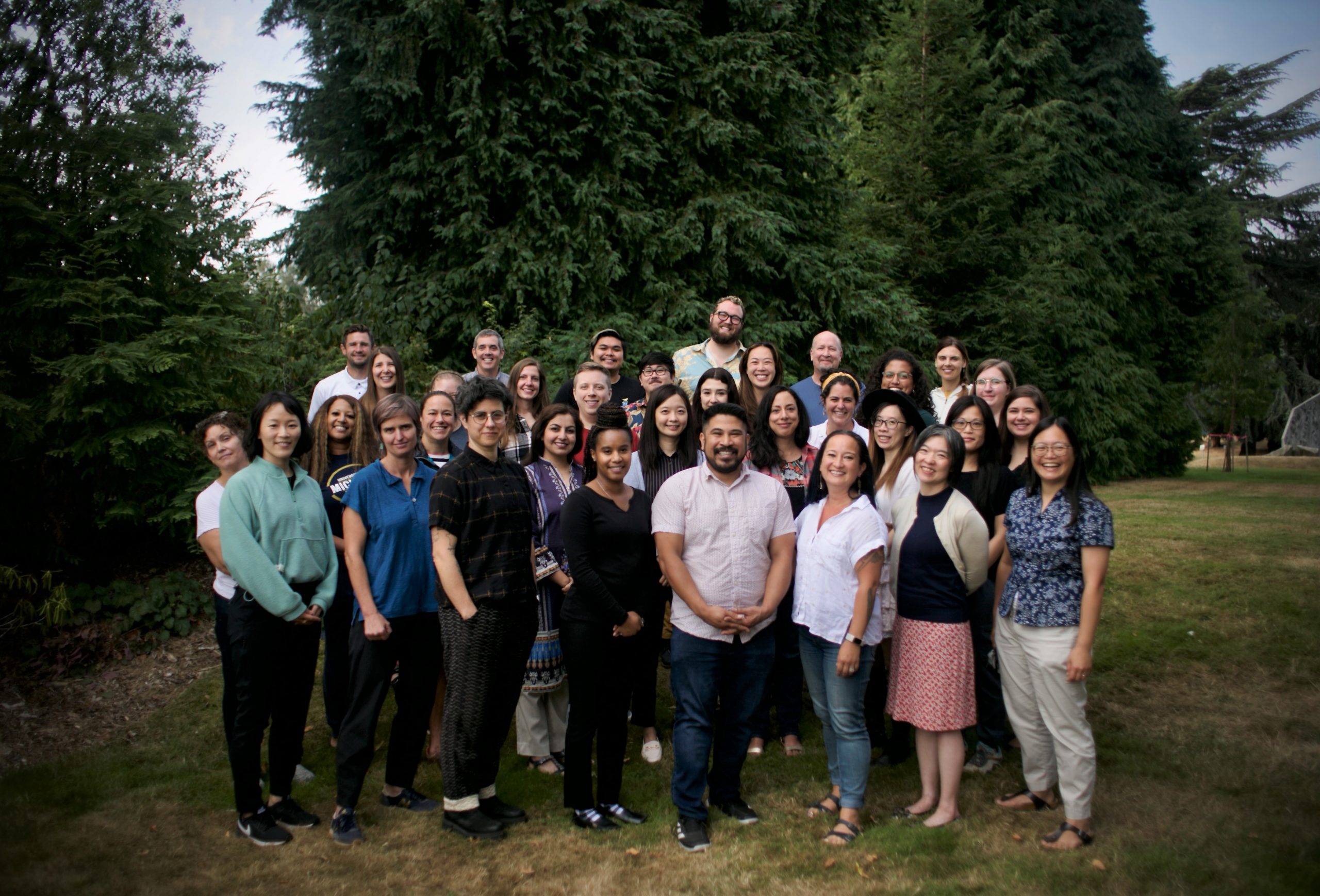 A photo of the Counseling Center Staff of 2022-2023. The group is smiling at the camera standing in front of a wooded area.
