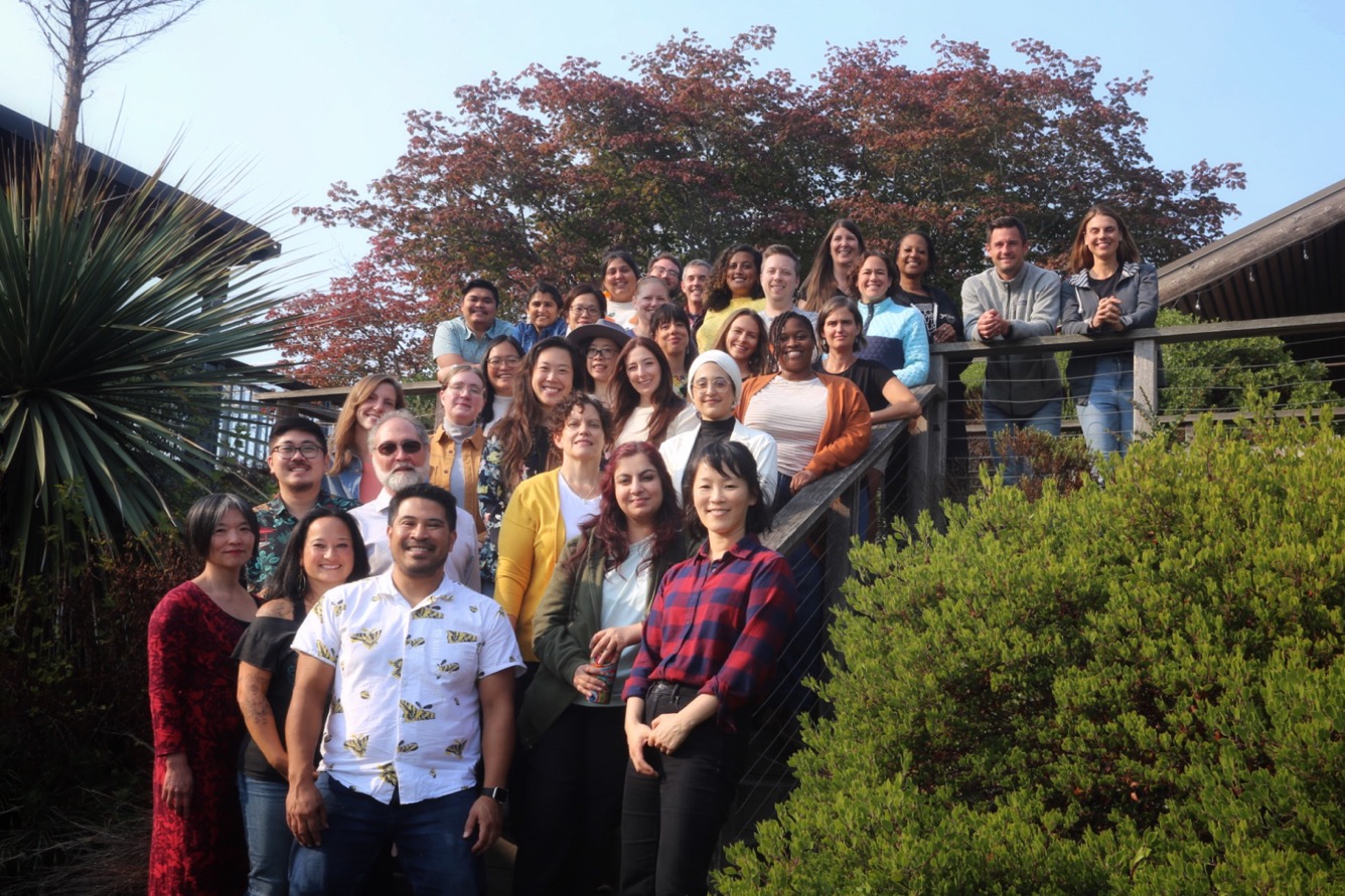 A photo of the Counseling Center Staff of 2023-2024. The group is smiling at the camera standing on a wood staircase.