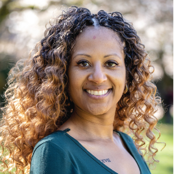 A smiling photo of Charisse Williams Phd , Counseling Center. Charisse has curly brown hair and is wearing a blue top.