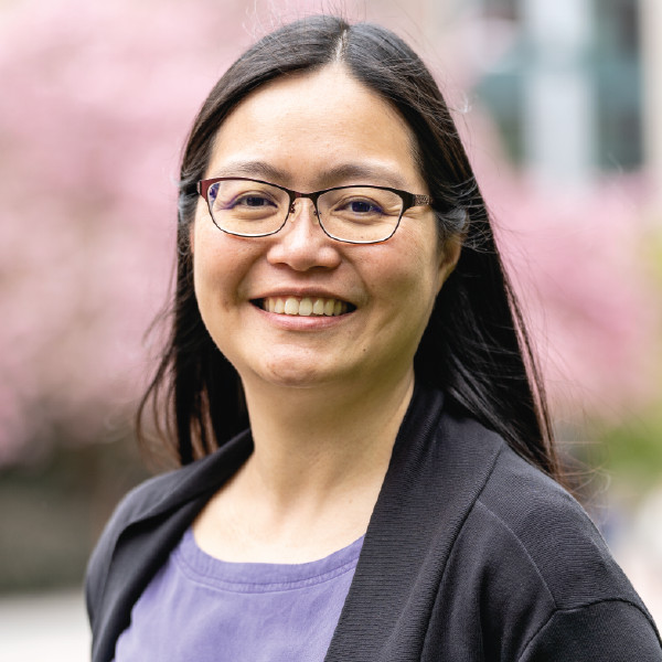 A smiling photo of Natacha Foo Kune Phd , Counseling Center. Natacha has long black hair and is wearing a purple top with a black jacket and glasses.