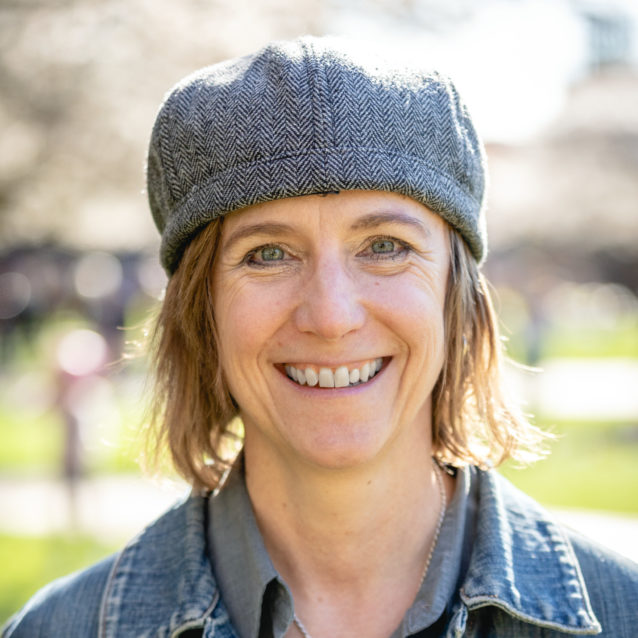 A smiling photo of Terri Pearson Ma , Health Health. Terri has short blonde hair and is wearing a denim top and cap.