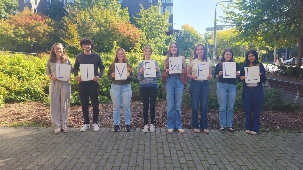 LiveWell Peer Health Educators each holding a sign that collectively spells out LiveWell